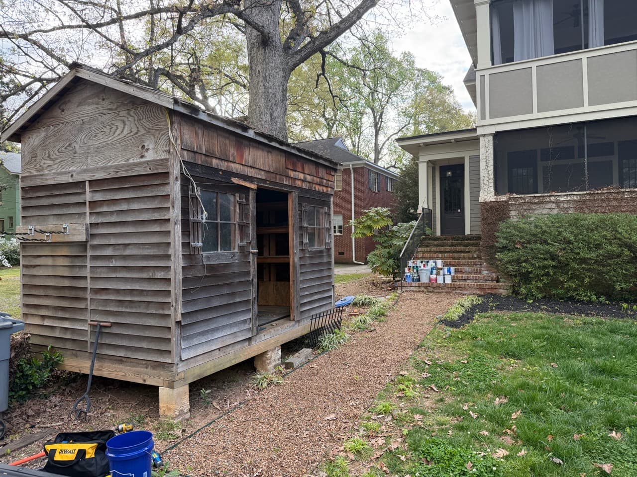 Weathered wood outbuilding beside a house